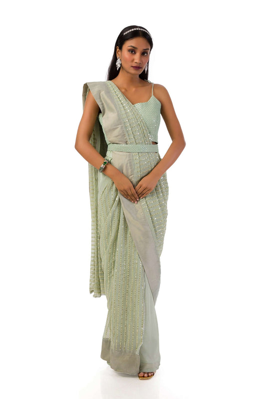 Model wearing an elegant olive green stitch drape saree set with intricate details.