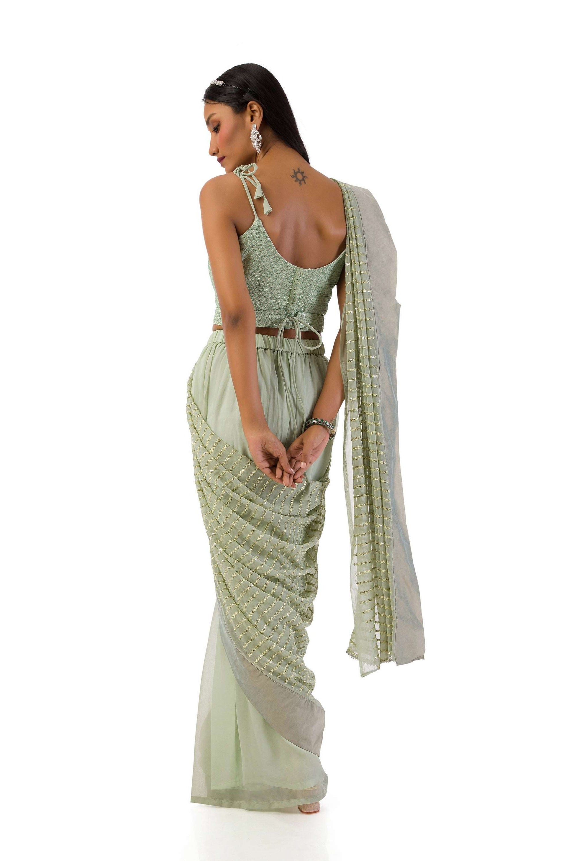 Model wearing an elegant olive green stitch drape saree set with intricate details.