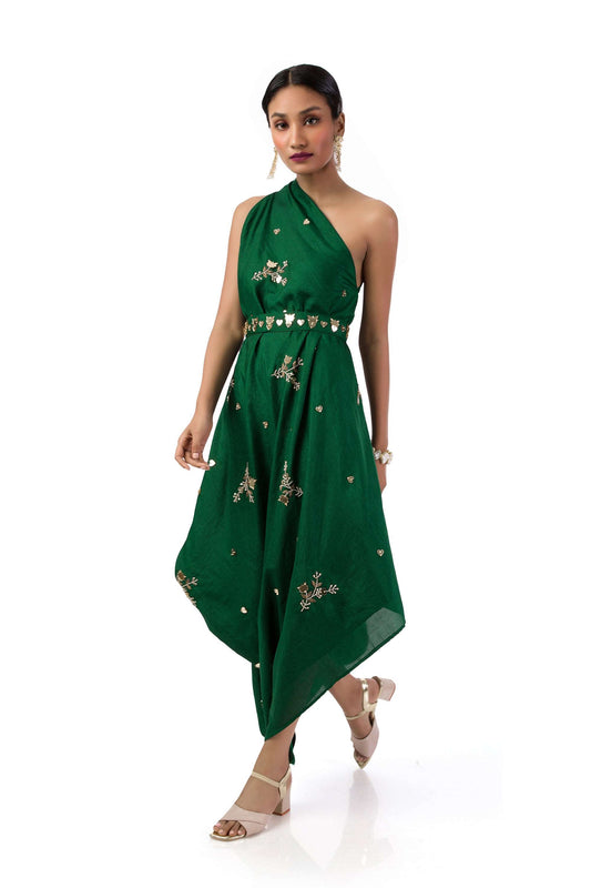 Woman wearing a bottle green one-shoulder draped gown in semi-silk with hand embroidery, paired with a matching belt.