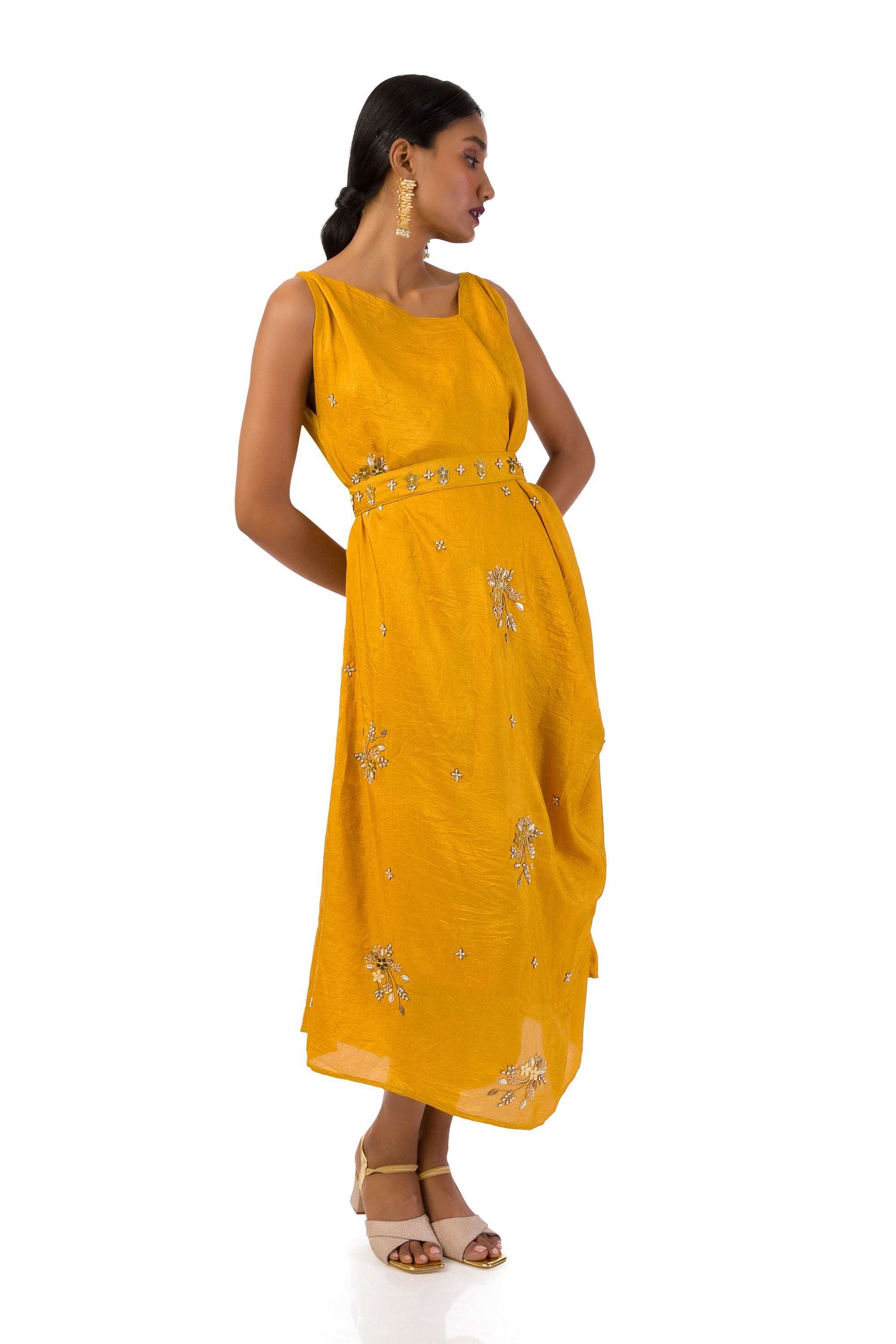 Woman wearing an elegant mustard Mahanadi dress with hand embroidery and a matching belt