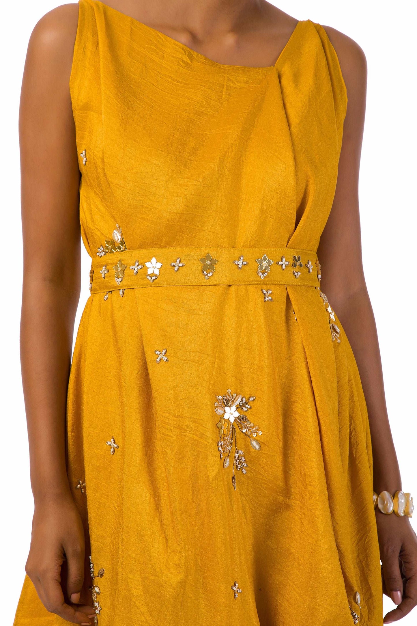 Woman wearing an elegant mustard Mahanadi dress with hand embroidery and a matching belt