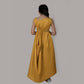 Girl wearing a mustard draped side cowl neck dress with hand embroidery and a matching belt